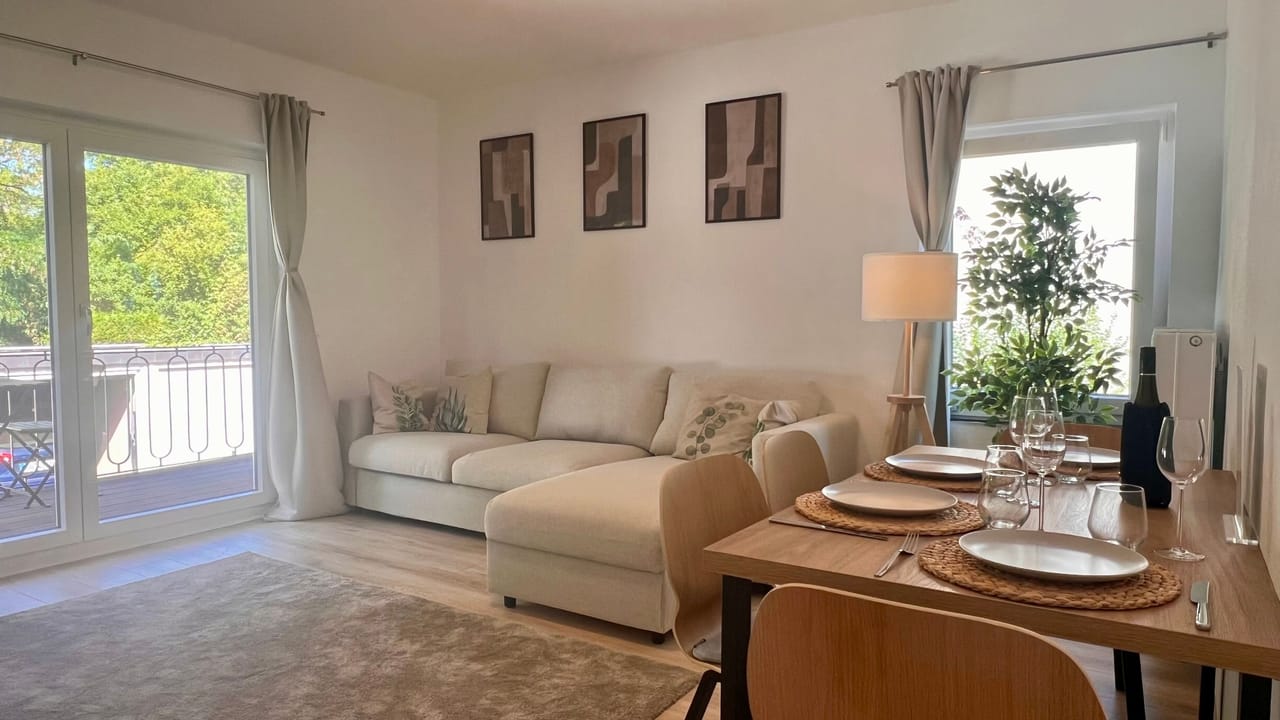 Wohn- und Essbereich mit Sofa, Esstisch und Balkontür im Apartment Freyenberger Weg in Königswinter