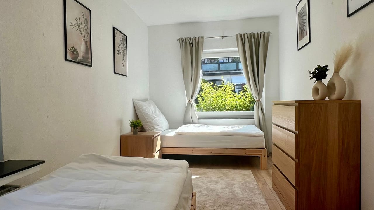 Schlafzimmer mit zwei frisch bezogenen Einzelbetten